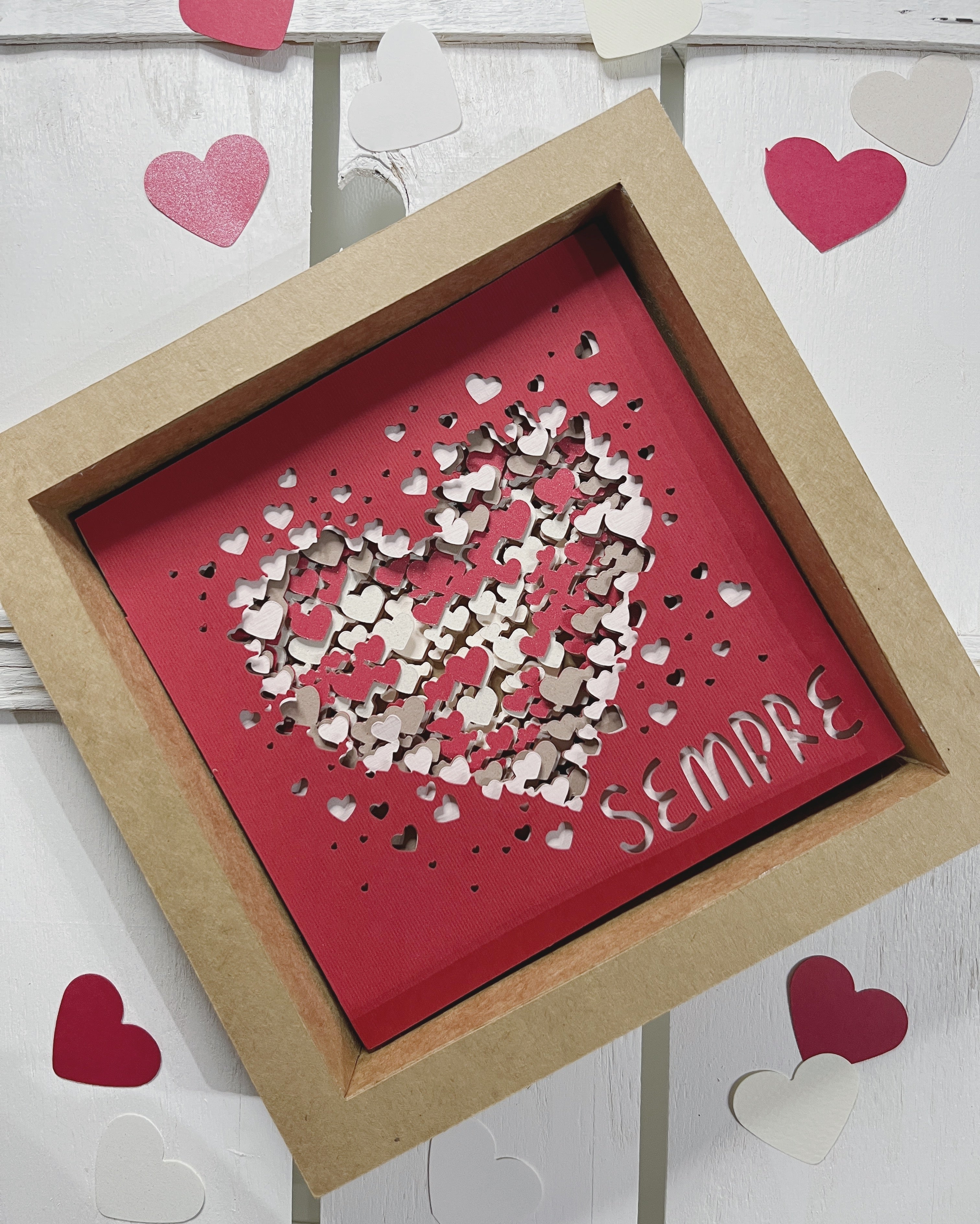 Quadro di carta con grafica di cuori intagliati e cartoncini sovrapposti