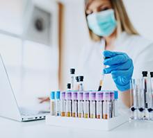 Laboratory worker handling samples using a mask and gloves