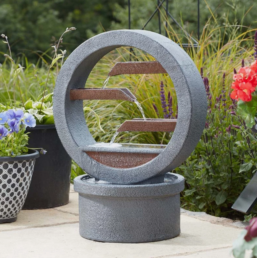 Decorative outdoor water fountain with circular design in a garden setting