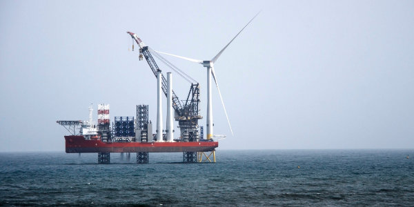 A wind turbine on a rig in the ocean A wind turbine on a rig in the ocean