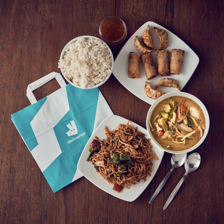 Eine Deliveroo-Tasche, umgeben von Essen