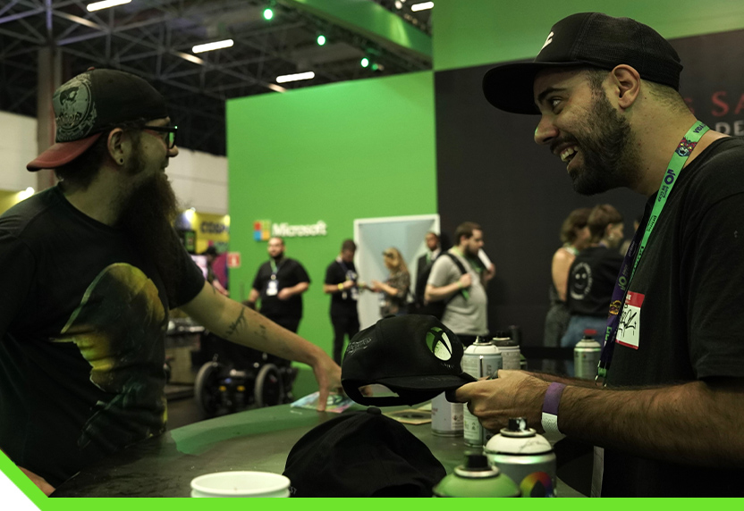 Los fans se reúnen en el stand de Xbox para personalizar gorras.
