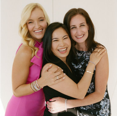Three women embrasing one another: HCM founders