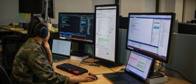 Un bureau avec plusieurs écrans d’ordinateur et un ordinateur portable.
