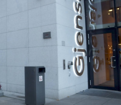 A building with glass doors and a sign displaying Gjens.