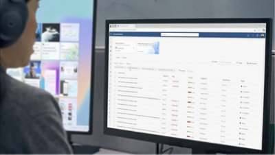 Человек в наушниках смотрит на экран компьютера, на котором отображается веб-сайт.