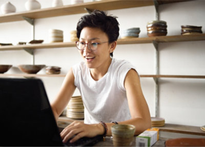 A woman sitting at a table using a laptop.