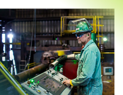 Osoba u zelenom kombinezonu i bezbednosnoj opremi