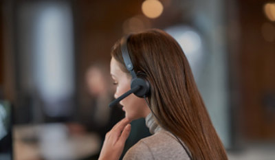 Mitarbeitende setzt ein Headset auf.