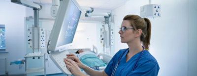 سيدة في نظارة ونظارة زرقاء تستخدم جهاز كمبيوتر.