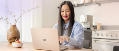 Wanita bekerja di laptop dengan perhatian terfokus.