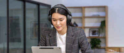  Een vrouw die een headset draagt terwijl ze op een laptop werkt