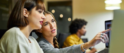Un grupo de mujeres mirando la pantalla de un equipo