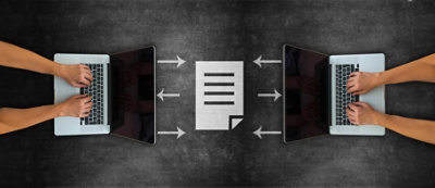 Two laptops with hands typing, facing each other, with a document icon in between them, and arrows pointing from the laptops 