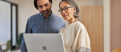 ノート PC を見て話し合っている男性と女性