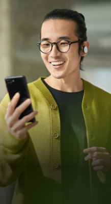 Un homme souriant regarde le téléphone mobile.