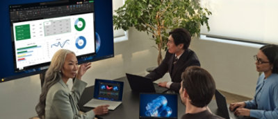Een groep mensen die naar een desktop kijkt