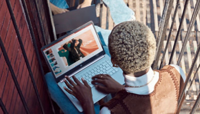 Eine Person tippt auf einem Laptop und sieht sich PowerPoint-Folien an