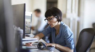 A person writing at their desk 