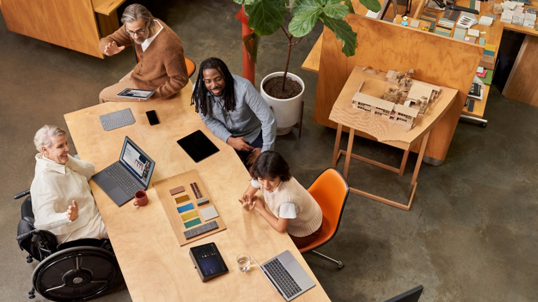 People in a conference room hold a meeting with remote participants.