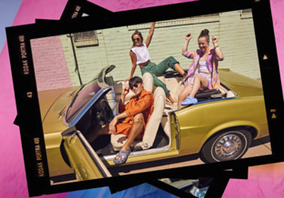A photo showing 3 people in a yellow open roof car having fun