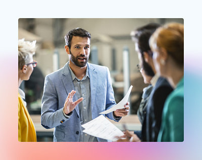 A person holding papers and talking to a group of people