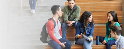 坐在視聽室交談的五個大學生。其中一個學生拿著平板電腦裝置。