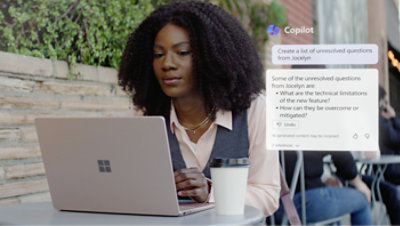 一名女士坐在桌前使用著膝上型電腦。