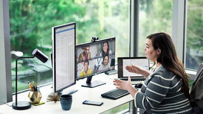 Female working at desk with multiple devices and running a Microsoft Teams conference call.