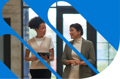 Dos personas caminan y mantienen una conversación. Una sostiene una tableta.