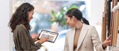 A person holding a tablet and a person looking at something