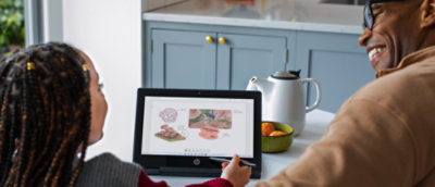 uma pessoa sentada à mesa a utilizar um portátil