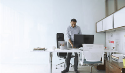Una persona in piedi e che lavora sul desktop in ufficio
