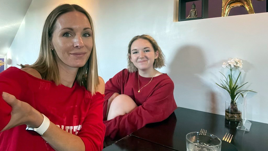 mother and daughter sit at a table...
