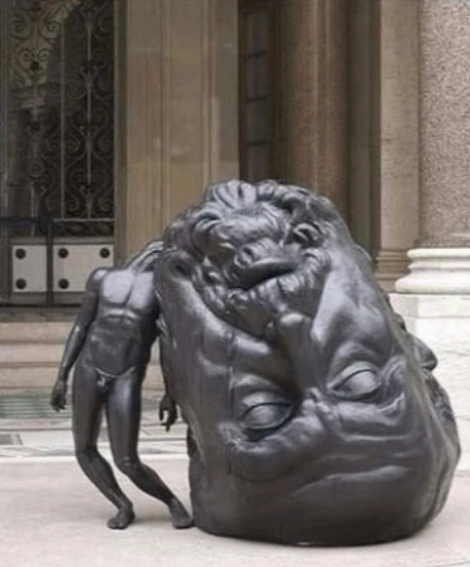 Statue of a naked man being weighed down by their massive head dragging on the ground.