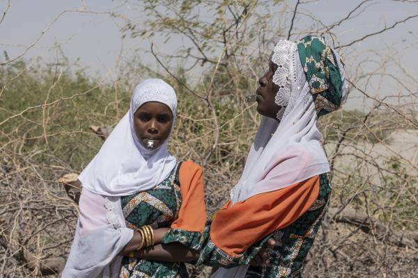 2 young girls standing in the desert with whistles in their mouths