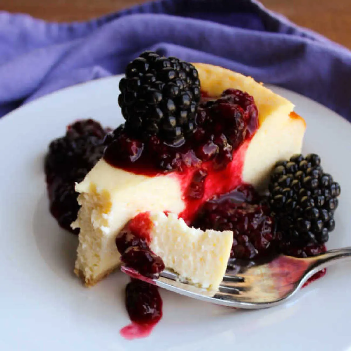 Cooking With Carlee 37 slice of creamy cheesecake with blackberry sauce.