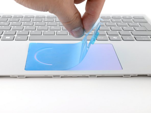 Use your fingers to peel and remove the alignment tool from the touchpad.