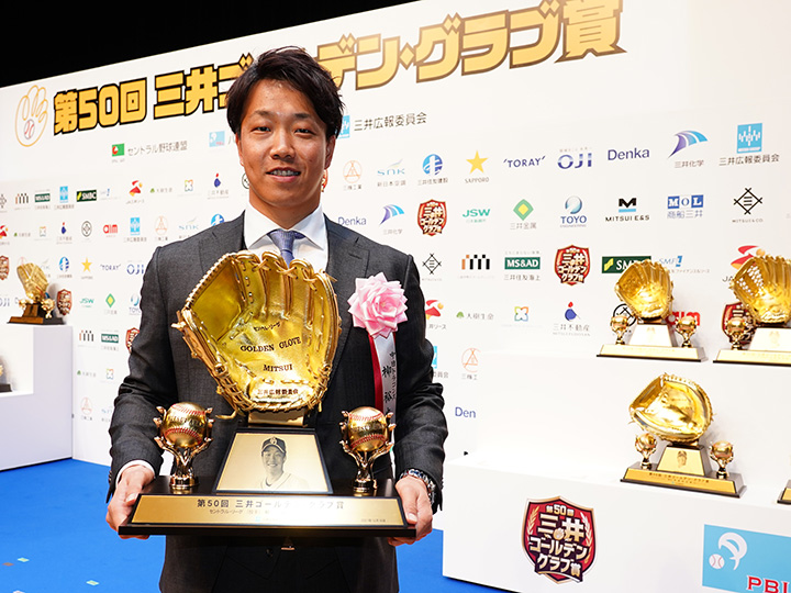 トロフィーを手に笑顔を見せる柳投手