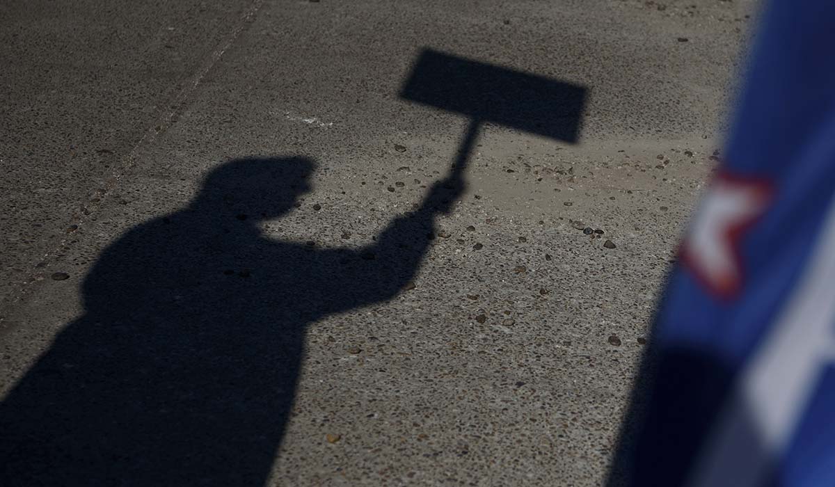The shadow of a voter holding a campaign sign. Photographer: Callaghan O'Hare/Bloomberg