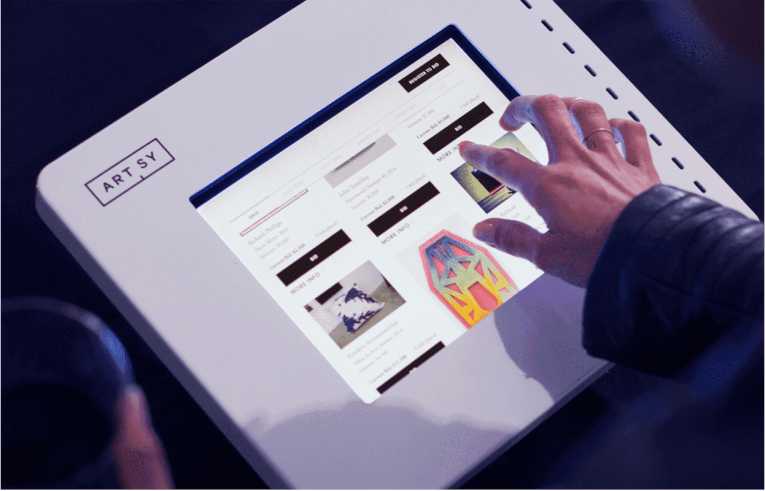 User browsing and placing bids on artwork using Artsy on a tablet