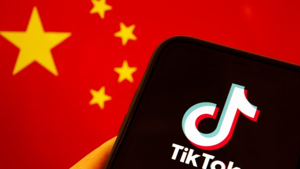 Smartphone mit TikTok-Logo vor chinesischer Flagge