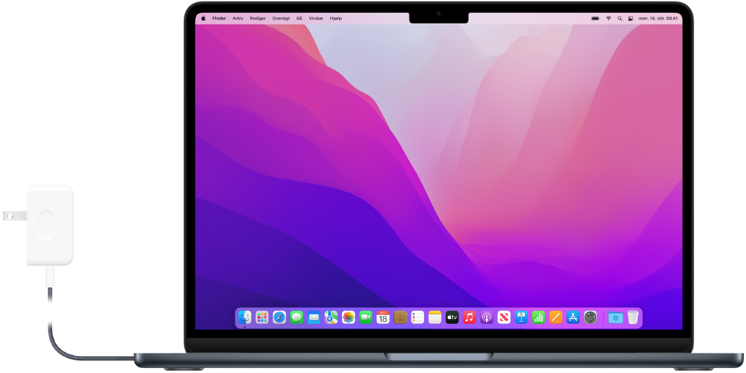 En MacBook Air med strømforsyningen tilsluttet.
