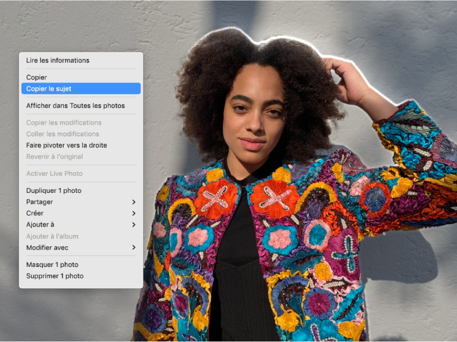 Un contour apparaît autour d’une personne qui se trouve au premier plan d’une photo, et un menu montre l’option « Copier le sujet » sélectionnée.