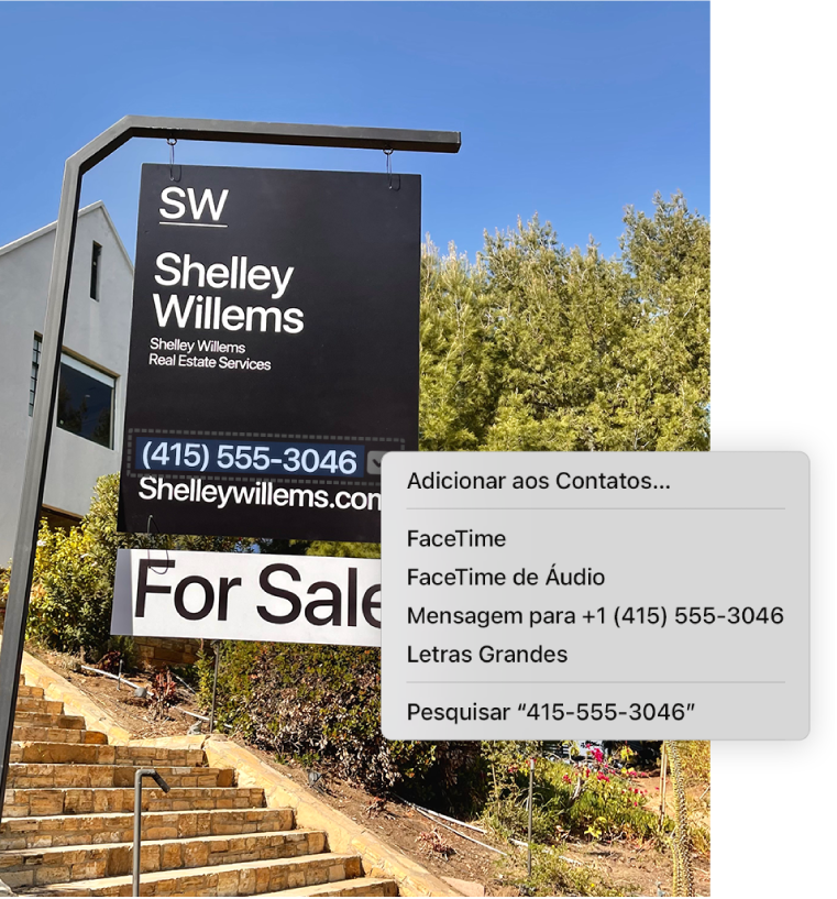 Foto de um anúncio de venda de uma imobiliária mostrando o número de telefone do corretor selecionado como um Texto ao Vivo e um menu exibindo as opções para adicionar o número de telefone aos Contatos, ligar para o número, fazer uma ligação FaceTime para o número, enviar uma mensagem de texto e outras opções.