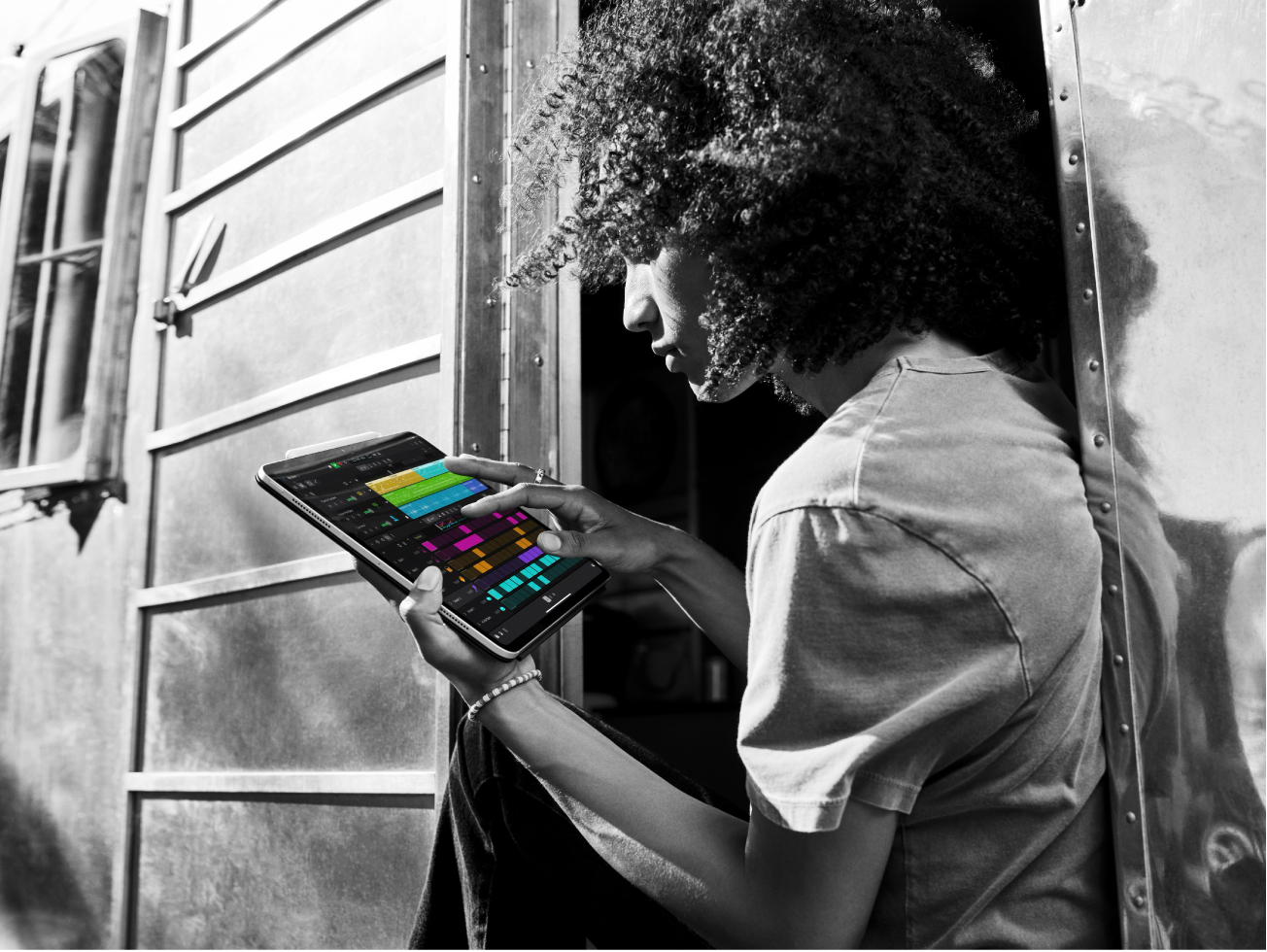 Ein Logic Pro-Projekt wird auf einem iPad wiedergegeben und eine Person tippt auf den Bildschirm.