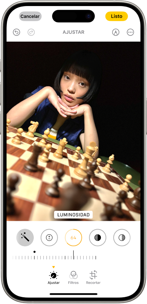 La pantalla Editar con una foto en el centro. En la parte inferior de la pantalla, de izquierda a derecha, se encuentran los botones Ajustar, Filtros y Recortar. Se selecciona el botón Ajustar y se muestra un regulador para ajustar el valor de Luminosidad. El botón Cancelar está en la esquina superior izquierda de la pantalla, y el botón Listo está en la esquina superior derecha.