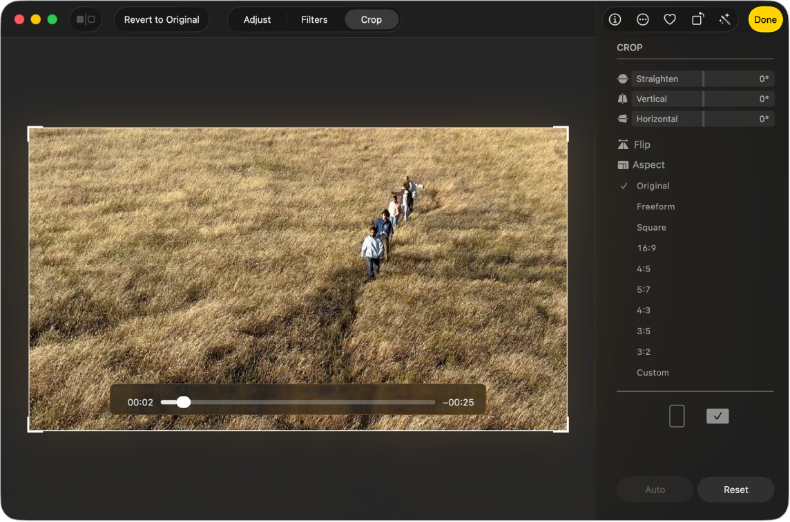 En video i redigeringsoversigten, der viser håndtag i hjørnerne, som du kan trække for at beskære videoen. I højre side er der mærker, som du kan trække for at rette videoen ud.