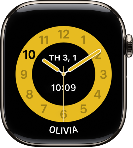 Mặt đồng hồ Giờ lên lớp đang hiển thị một đồng hồ kim với ngày và giờ đồng hồ số ở gần trung tâm. Tên của trẻ sử dụng đồng hồ nằm ở dưới cùng.