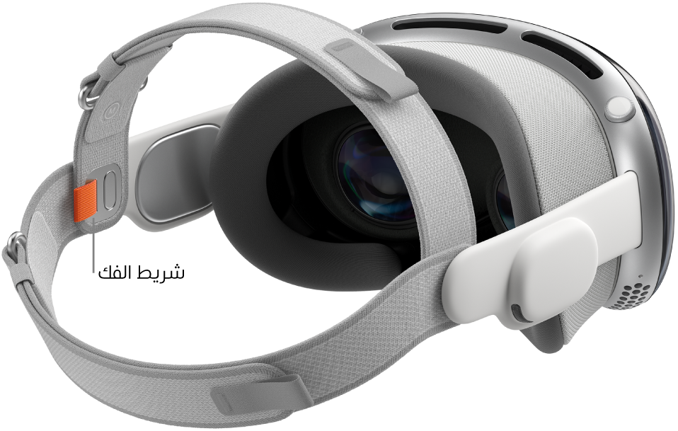 Apple Vision Pro ملحق بها الحزام بشريطين. يظهر لسان تحرير برتقالي على الجانب الداخلي من الحزام بشريطين.